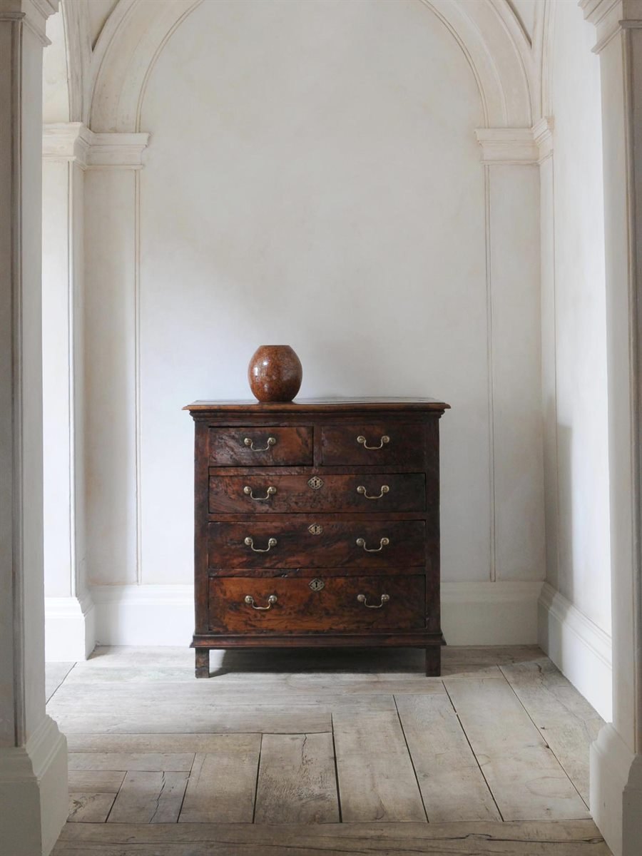 Antique chest with ceramic vessel in a quiet architectural interior